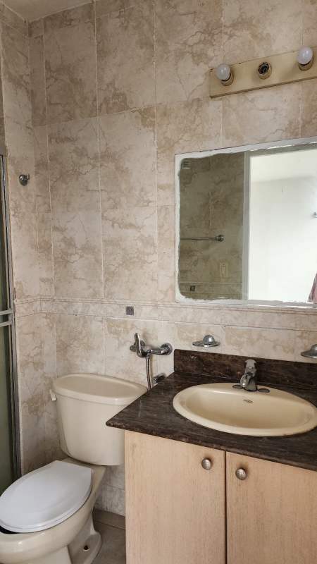 Contemporary bathroom with vanity counter, mirror, glass shower, beige tile PH Vista del Mar Panama