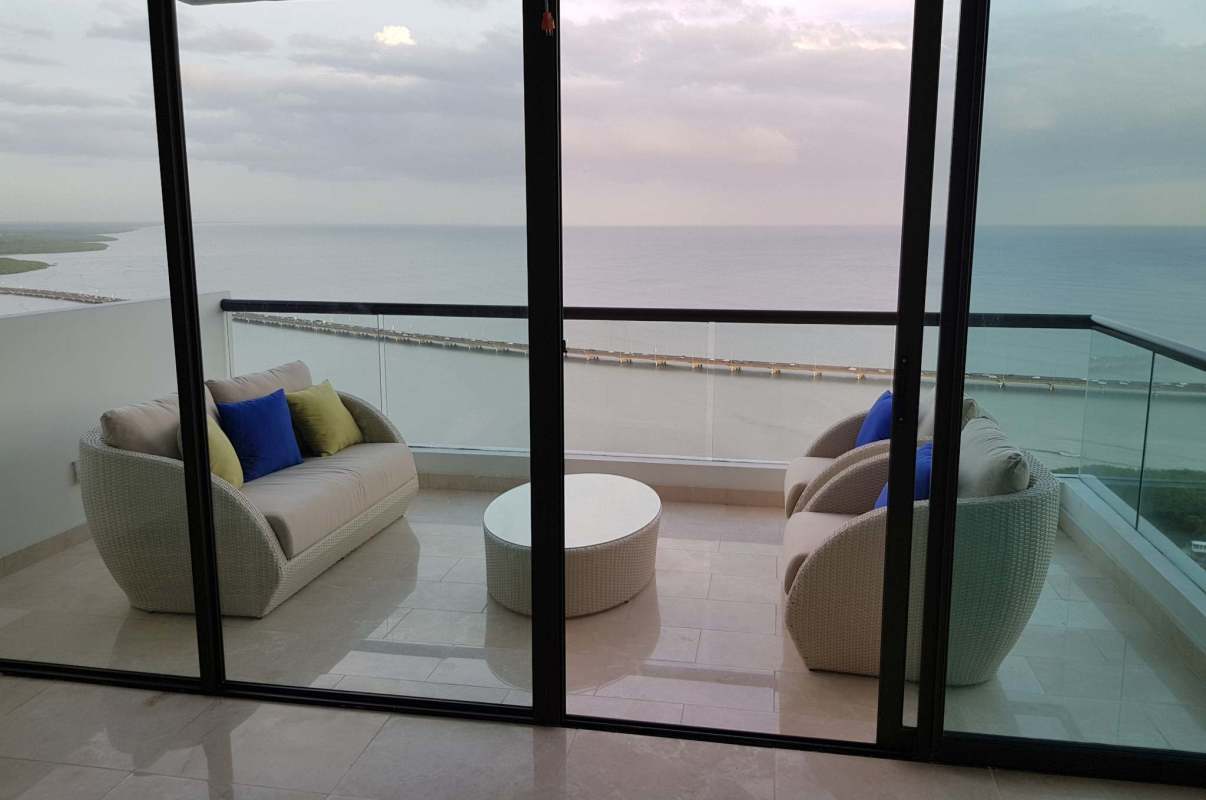 Dining area with large windows and marble floors in oceanfront apartment Coco del Mar Panama.