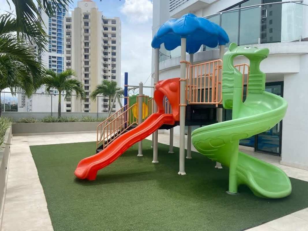 Expansive private balcony with glass railing, overlooking Pacific Ocean and city skyline.
