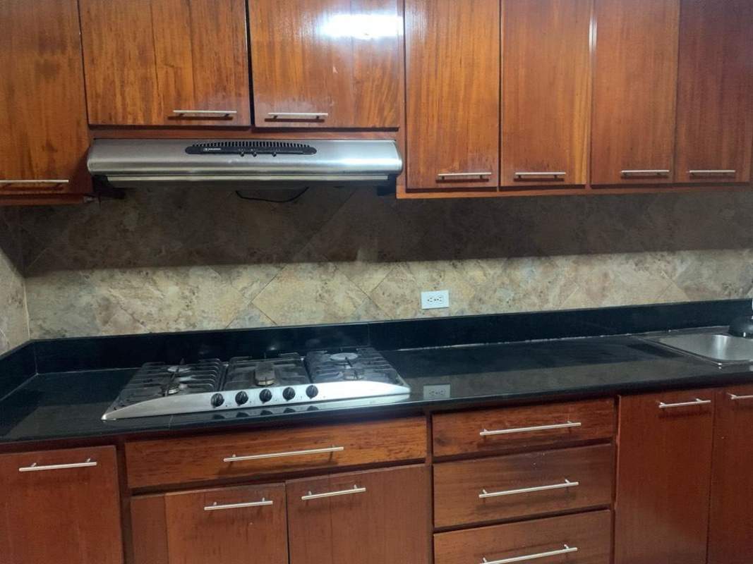 Large kitchen with granite countertops, wooden cabinetry, double sink in Deco Plaza Obarrio Panama