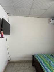 Minimalist bedroom with bed, mounted TV, AC ready, tile floor in central Chitré.