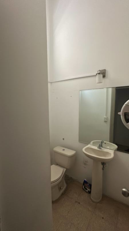 Clean tiled bathroom with pedestal sink and mirror in commercial space for rent Via Argentina Panama