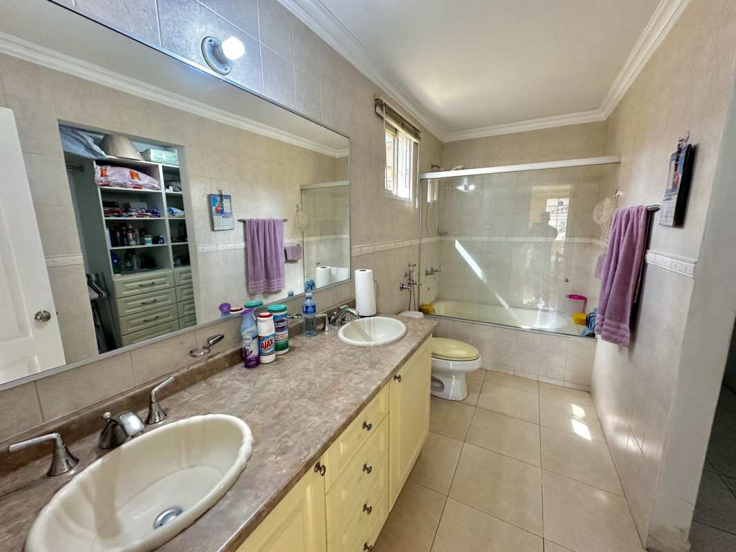 Traditional bathroom featuring double sink, bathtub, tiled walls in Golden Springs Panama City house