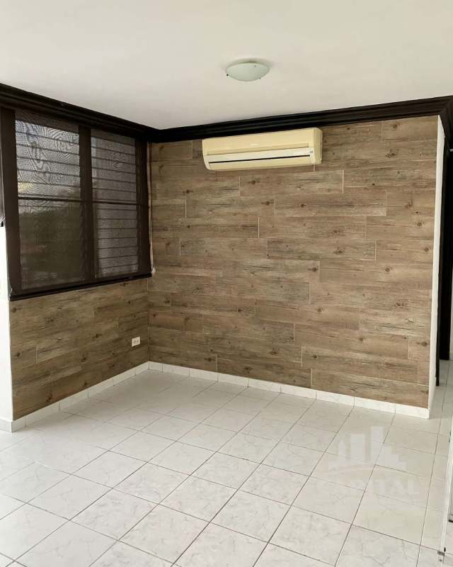 Living room with wood-look accent wall, large window, AC unit apartment for rent PH Dos Mares Betania Panama