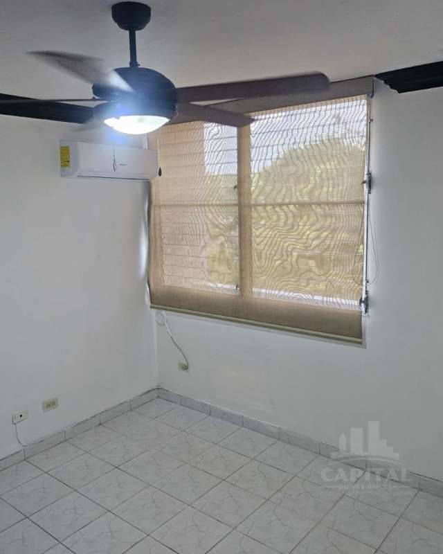 Living room with ceramic tile floor, wood accent wall, ceiling fan and AC at PH Dos Mares apartment Betania Panama