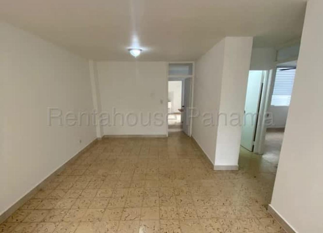 Empty living room with beige tiled floor, large windows, open layout in Parque Lefevre Panama apartment for sale