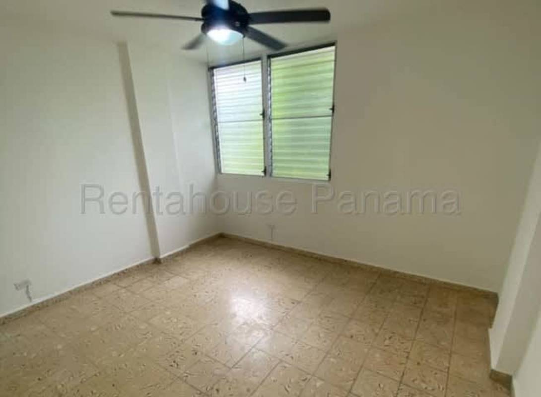 Bedroom with louvered windows, ceiling fan beige tile floor Parque Lefevre Panama apartment