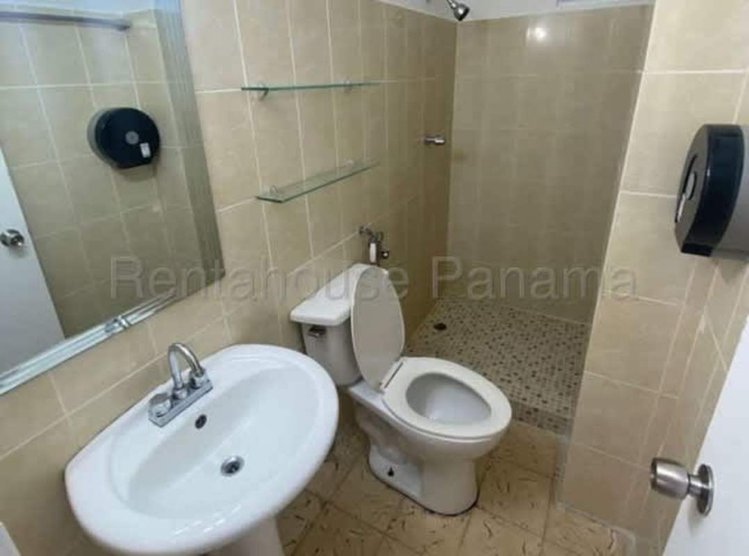 Contemporary bathroom with beige tiles, walk-in shower, sink and glass shelves Parque Lefevre apartment Panama