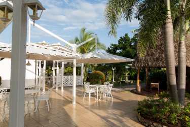 Lush tropical landscaping with palm trees and covered gazebo lounge La Casa Amarilla Punta Chame