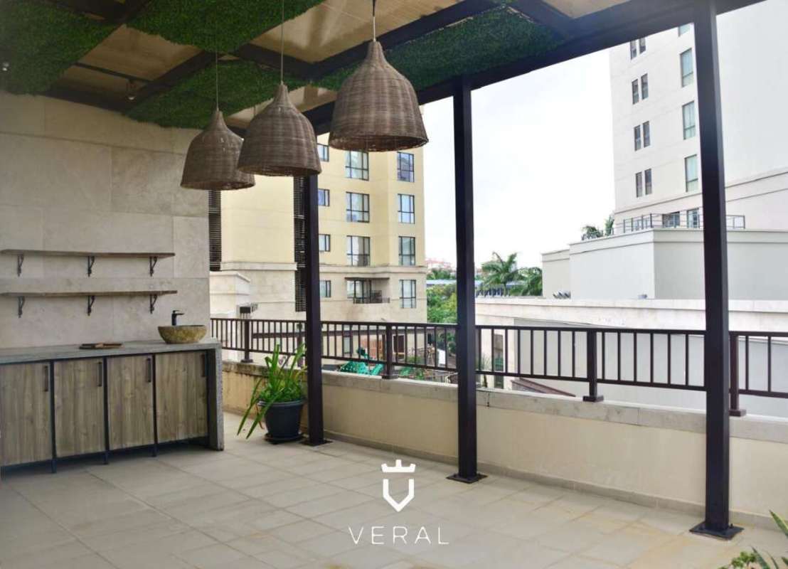 Modern outdoor terrace with kitchenette, hanging lights, greenery PH Santa Maria Court Panama