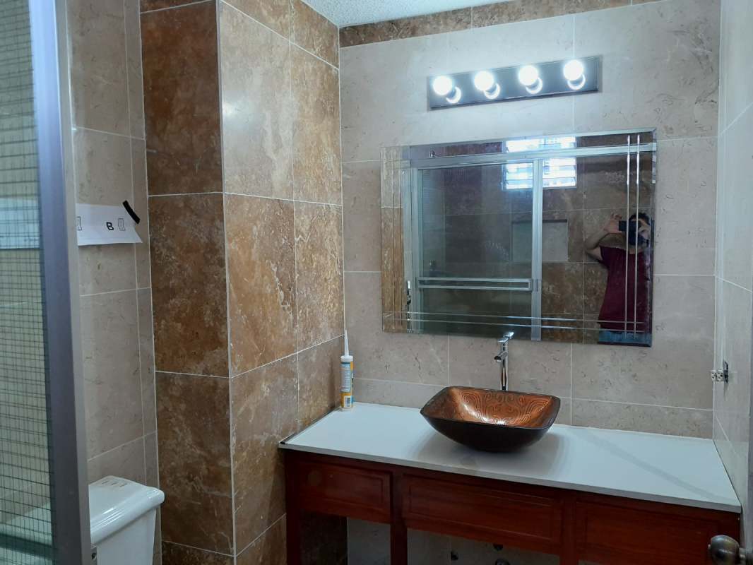 Bathroom with vessel sink, marble tile and glass shower in Marbella apartment Panama