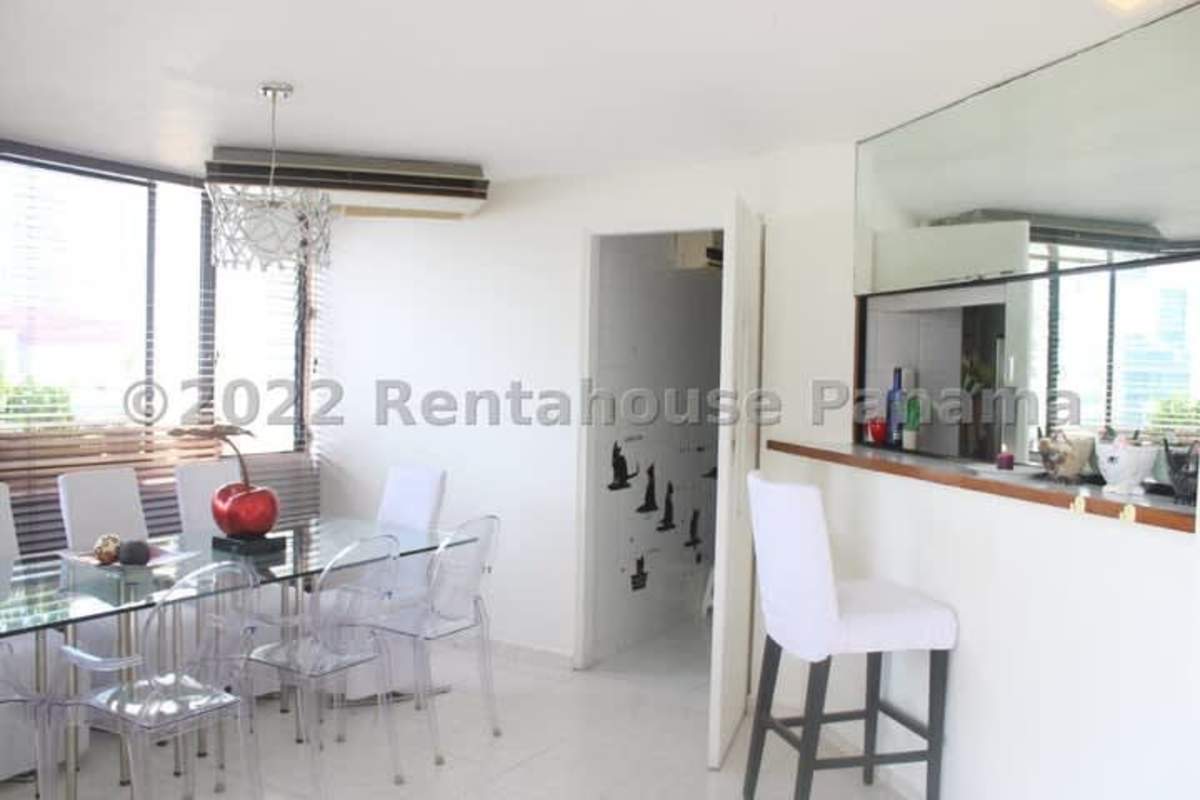 Dining room with glass table, modern lighting, large window PH Marbella 25 Panama City
