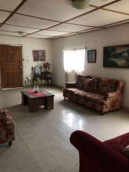 Traditional living room with sofa and artwork in Montijo family house for sale Panama