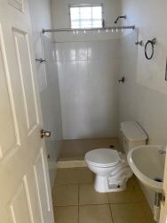 Small bathroom white tile sink toilet walk-in shower Barrio Balboa La Chorrera