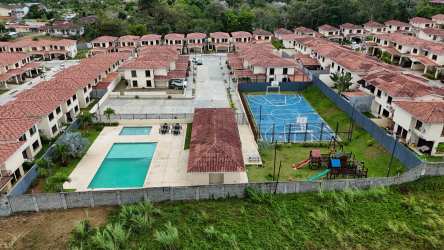 Aerial photo showing community pools, playground, sports courts, townhouses Senderos de Bambú