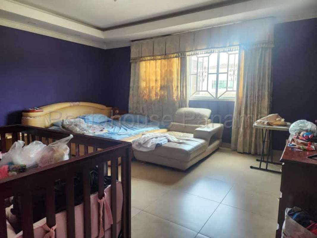 Large bedroom with purple accent walls and tile flooring House in Condado del Rey Panama