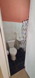 Compact bathroom with toilet, sink and shower in Burunga studio rental Panama