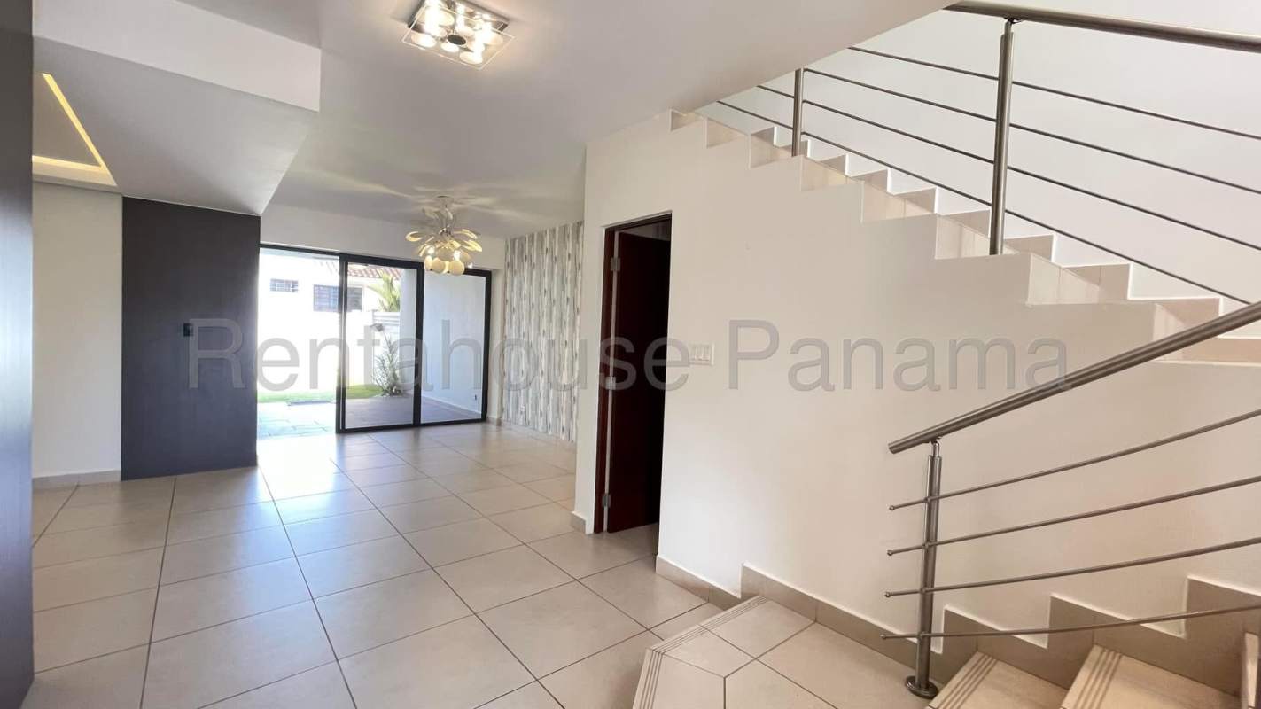 Modern staircase and living area with tile floors and chandelier in Brisas del Golf Panama