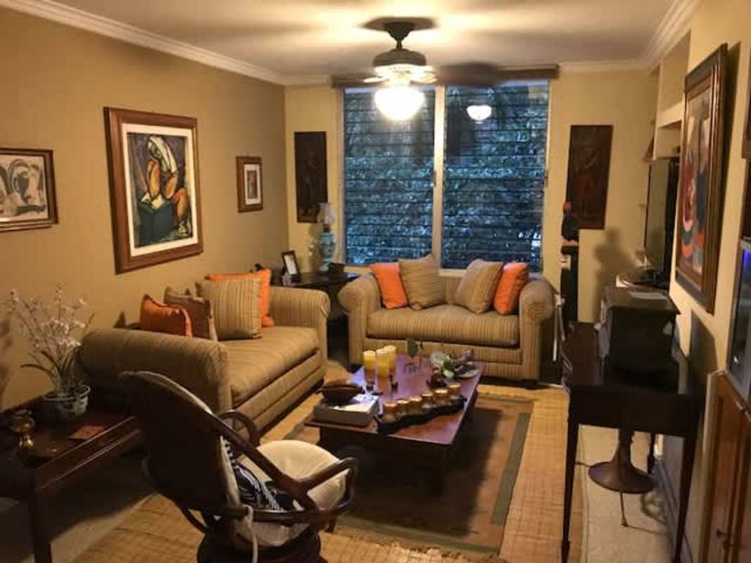 Living room with large windows, greenery view, eclectic furnishings at PH El Cenit La Cresta Panama