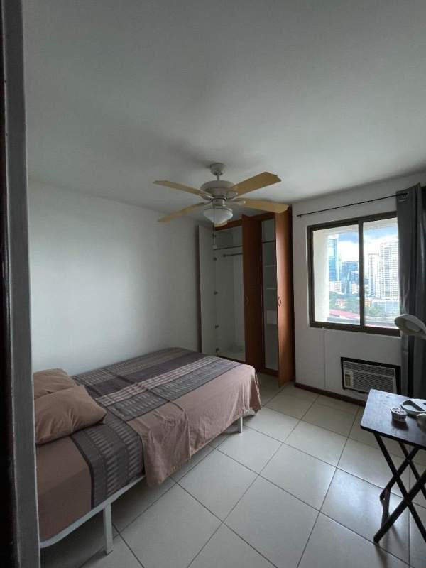 Minimalist living room with black leather sofa large windows ceramic floor Punta Pacifica