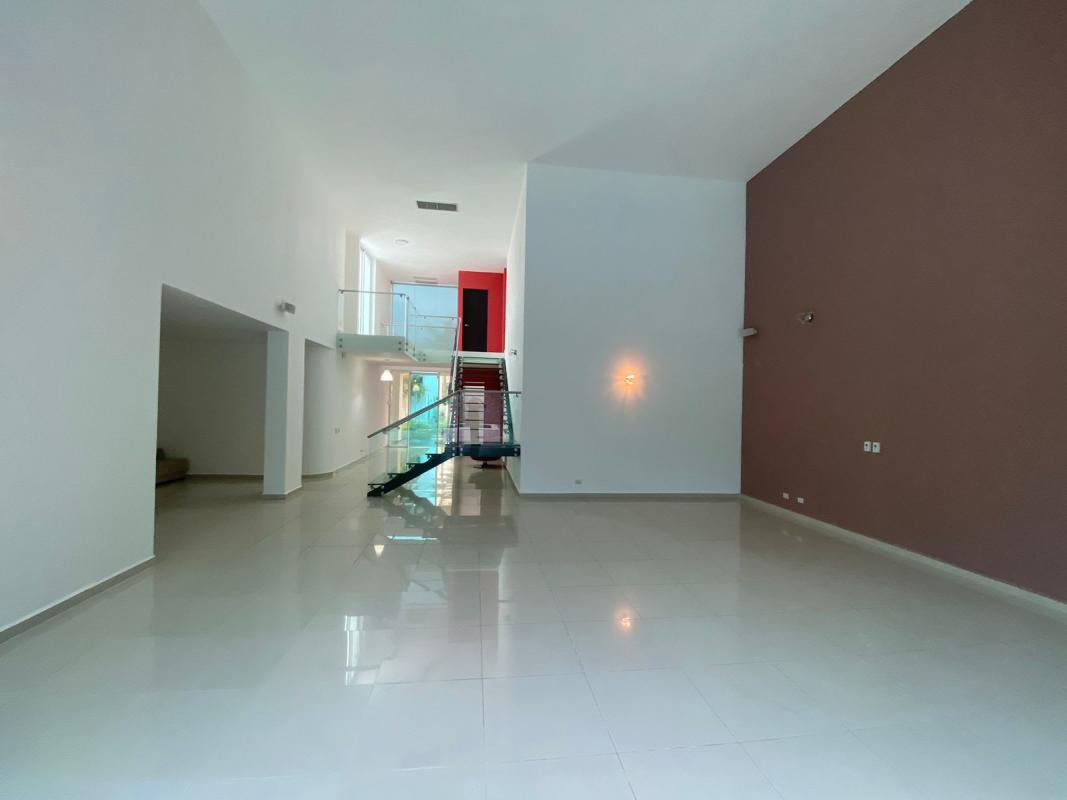 Entry foyer with glass staircase, high ceilings, large windows in Costa Sur home
