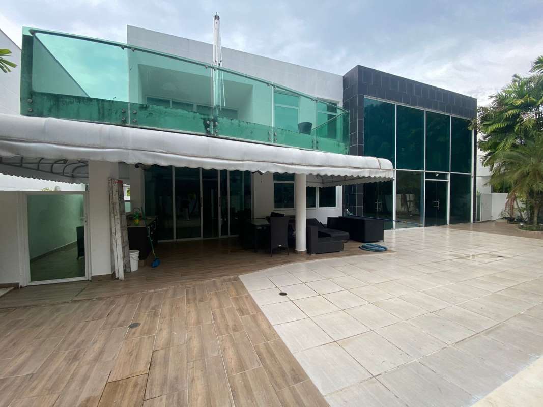 Bright bedroom with large window and chandelier in Costa Sur house for rent