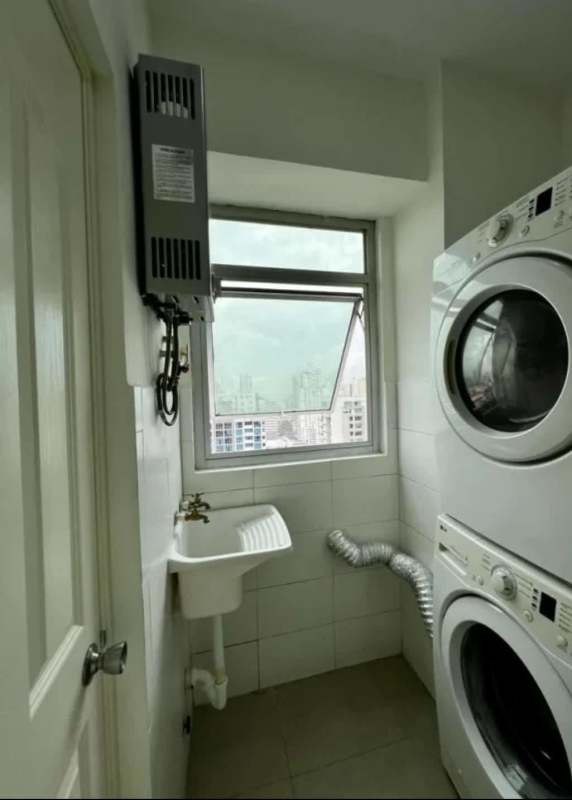 Laundry room with washer dryer, sink, window in PH San Francisco Bay apartment Panama
