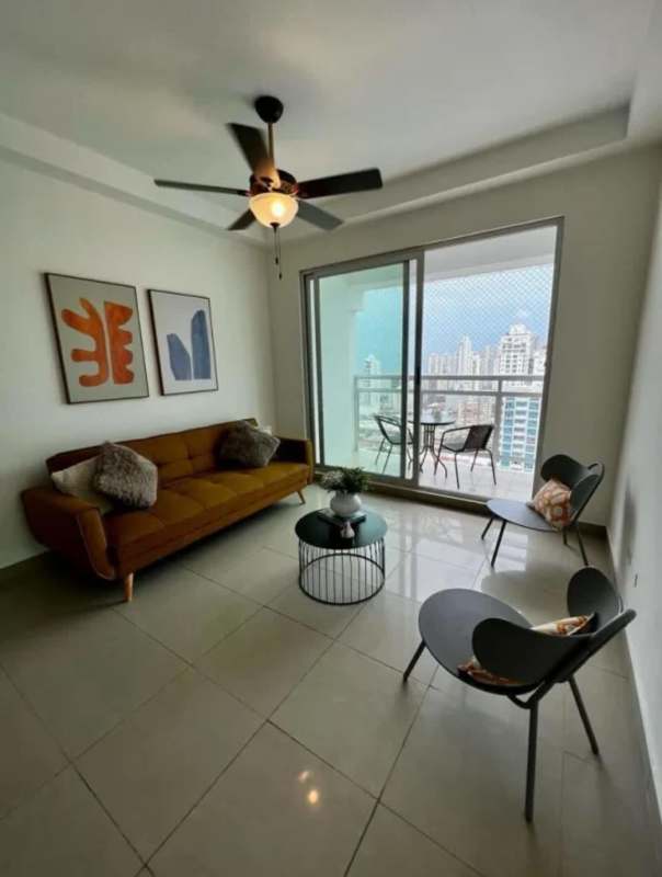 Living room with sofa, balcony access, city view in furnished PH San Francisco Bay apartment Panama City