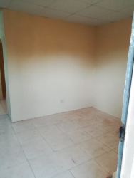 Unfurnished living space with beige tiled floors and plain walls in Puerto Caimito apartment