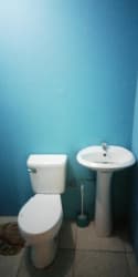 Bathroom with blue painted walls, pedestal sink and tile flooring in Puerto Caimito apartment