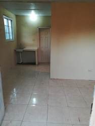 Simple kitchenette with ceramic tiles and a window in Puerto Caimito apartment Panama Oeste