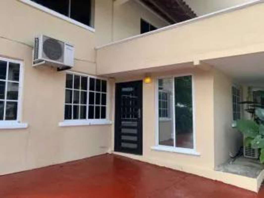 Bright living room with modern art, white chairs, tile floors, in Albrook Panama home for rent