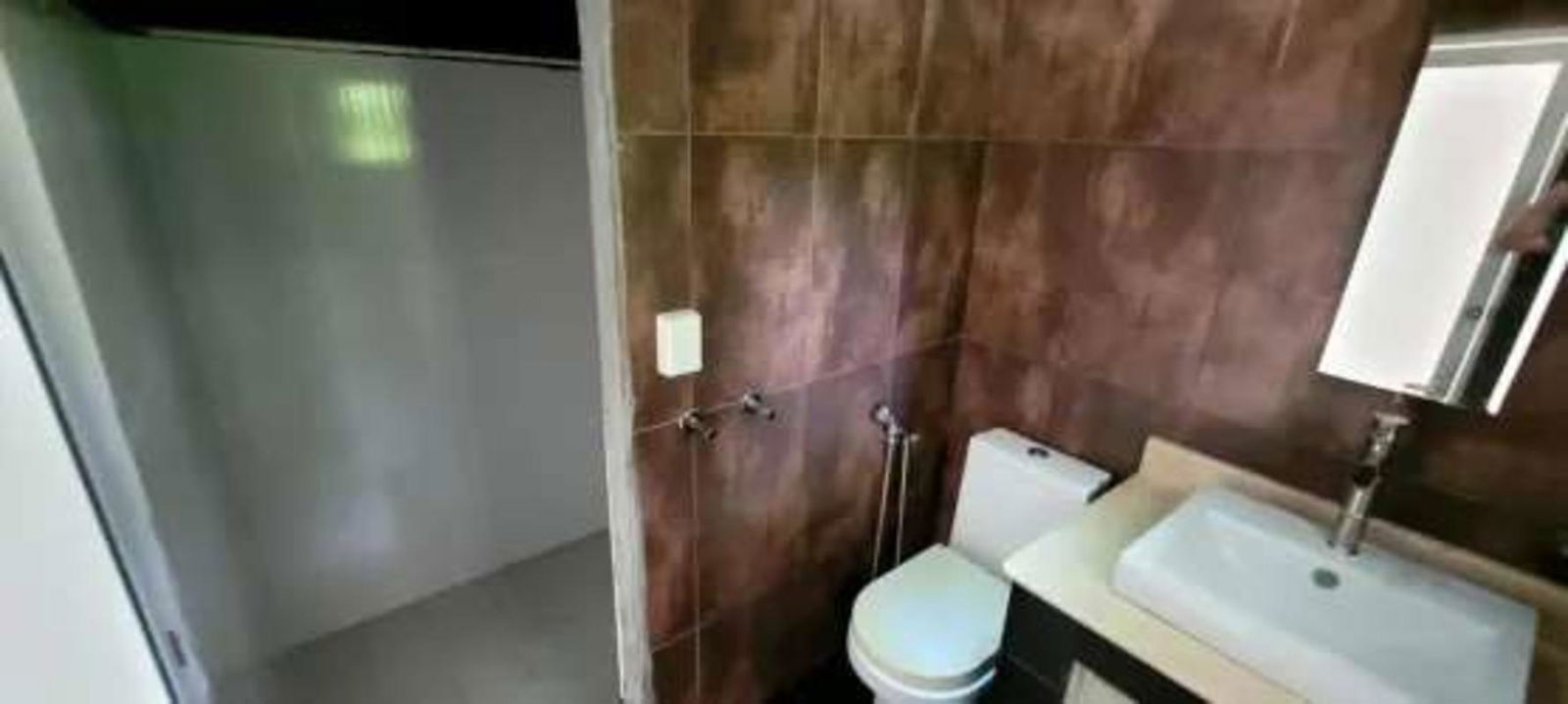 Large tiled living room with glass sliding doors opening to green garden in Albrook Panama