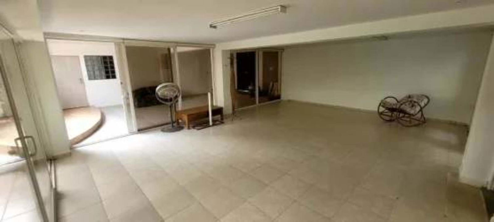 Shaded terrace with tiled roof surrounded by garden and palm trees in Albrook Panama