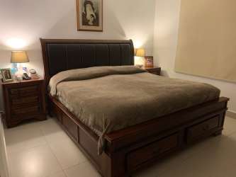 Spacious bedroom with wooden bed and nightstands fully furnished in Panama Pacifico Woodlands
