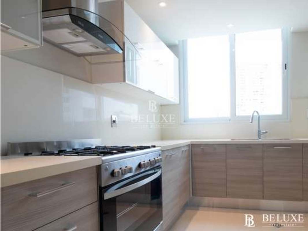 Decorated master bedroom featuring large windows, city and ocean views in The Regent Panama Costa del Este