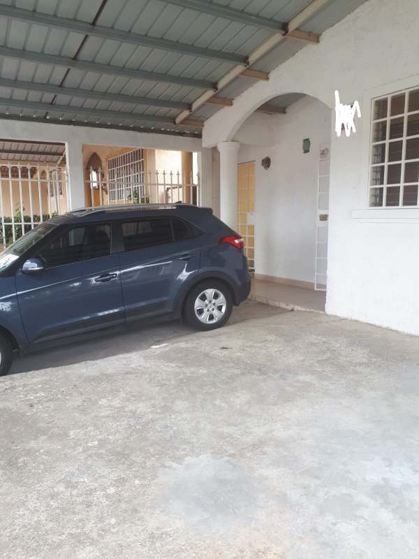 Covered carport with metal roof and fenced entrance at Colinas del Sol house Panama Oeste
