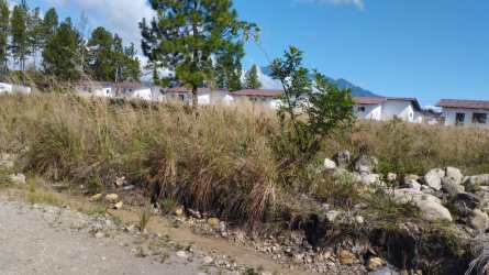 Open grassy lot with white houses and mountain view Las Trancas Boquete Panama