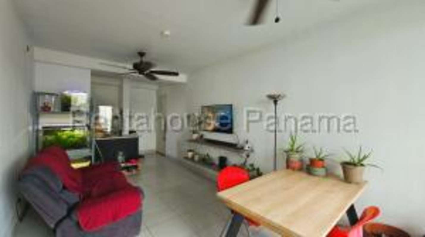 Bright open-plan living and dining space with red accent chairs and large windows PH Ilo Juan Díaz Panama