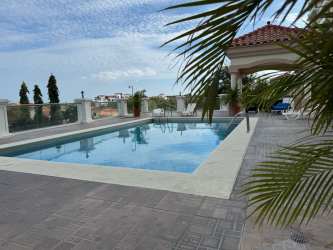 Open kitchen with marble counters and panoramic windows at Vista Mar penthouse San Carlos