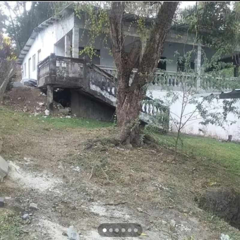 Rustic elevated porch with staircase and balustrade facing large yard Pedregal Panama