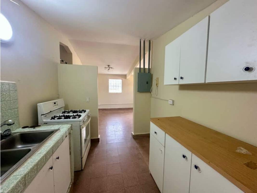 Simple kitchen with gas stove sink tile countertops white cabinets rental home Chanis Panama
