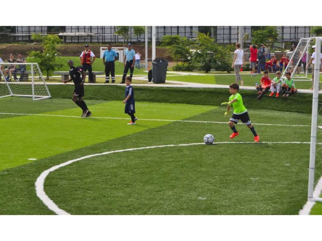 Kids playing soccer in mini-field with greenery PH Bali Costa del Este