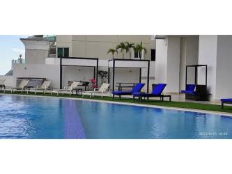 Bright living room with floor-to-ceiling windows opening to ocean view balcony at PH Oasis Punta Pacífica Panama