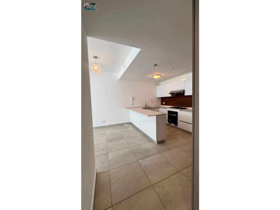 Kitchen with island, pendant lights, skylight, and white cabinetry in PH Van Gogh Panama