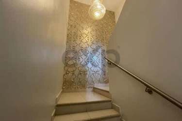 Interior staircase with gold accent wall, pendant light in Woodlands Panama Pacifico house