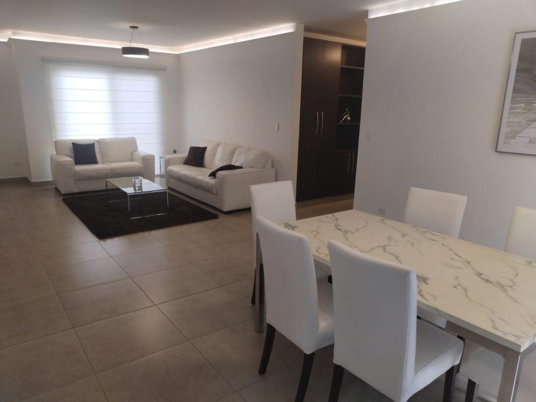 White leather sofas, glass table, large bright windows at PH Embassy Village Clayton