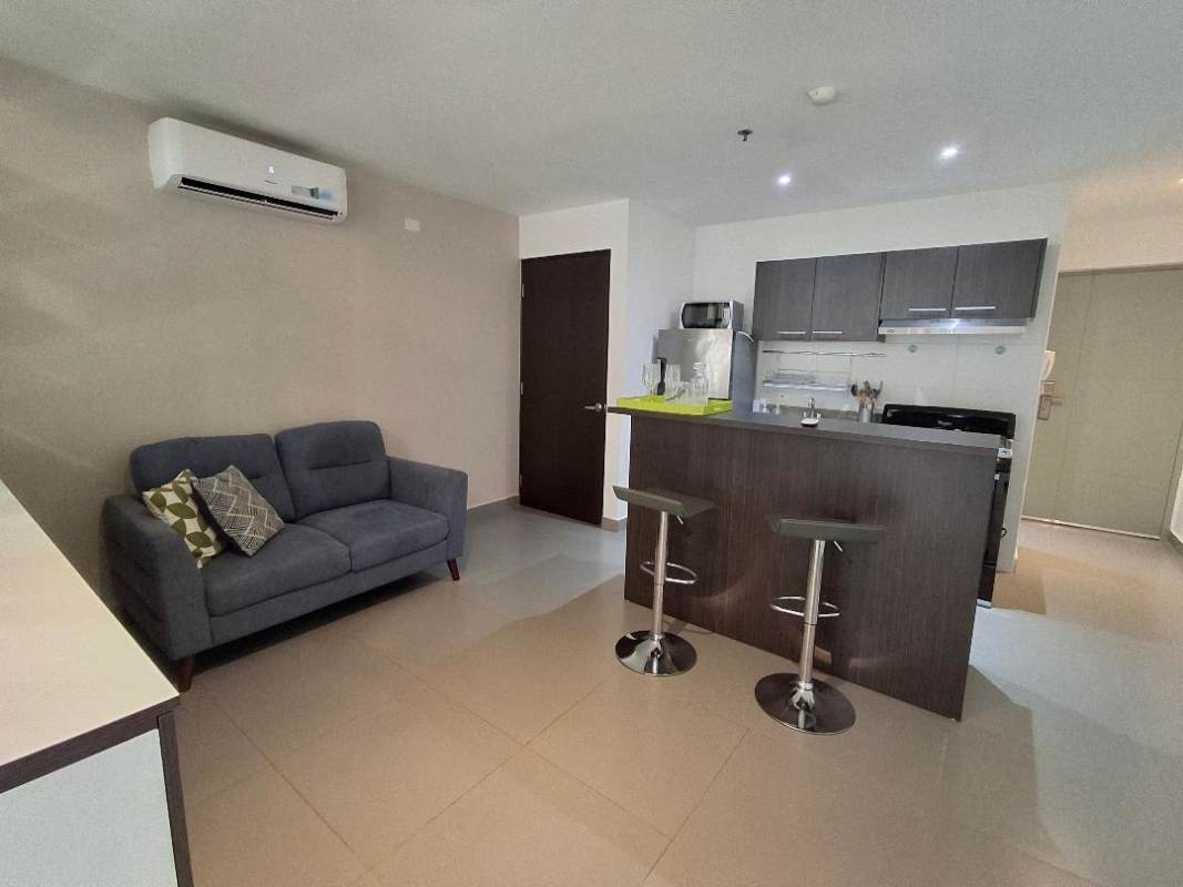 Open plan kitchen living space with bar counter, sofa, appliances PH Colores de Bella Vista Panama City