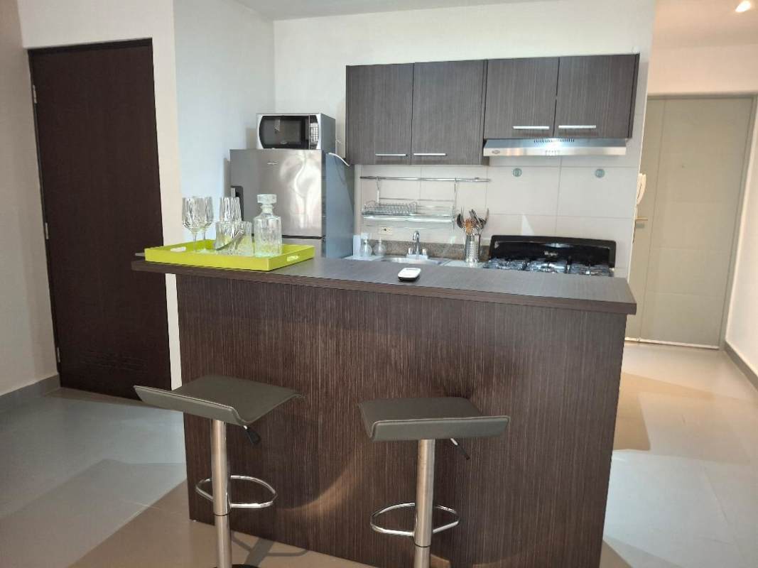 Minimalist living area with built-in shelves, blue loveseat, AC and bar counter at PH Colores de Bella Vista Panama City