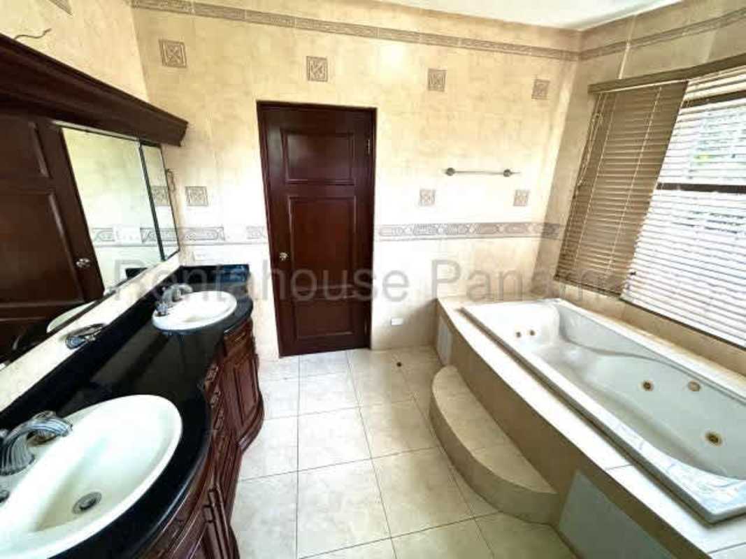 Walk-in closet with wood shelves and tile floor in luxury master suite Llanos de Curundu Albrook Panama